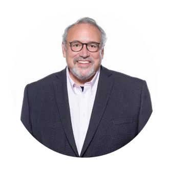 man with glasses wearing suit with open collar shirt.