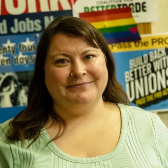 Woman in green shirt standing in front of labor posters.