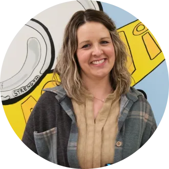 Portrait of Katie Weiner, an instructional paraprofessional at Thompson Elementary School and a finalist for North Dakota United's 2027 Education Support Professional of the Year. She smiles in front of a colorful school mural.