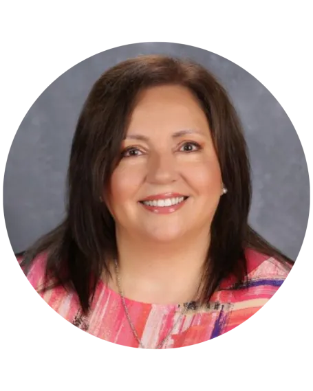 headshot of woman with dark hair and pink pattern shirt
