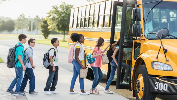 line of students getting on school bus