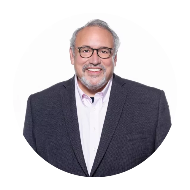 man with glasses wearing suit with open collar shirt.