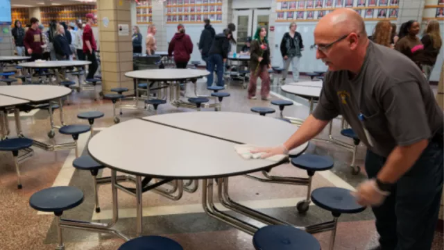 Man wiping down lunch table