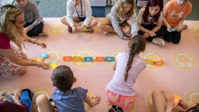 group of elementary school kids sitting on classroom floor