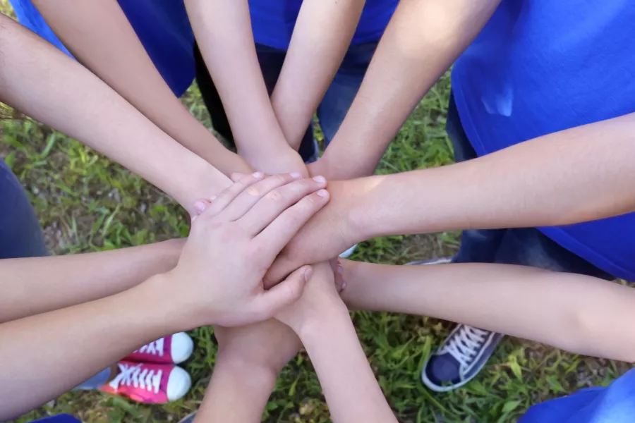 group of people with hands in a circle
