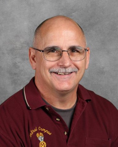 headshot of man with a mustache and glasses wearing maroon polo shirt